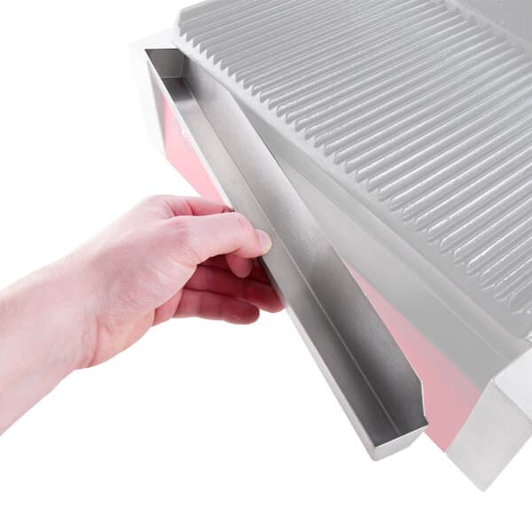 A hand holding a metal drip tray.