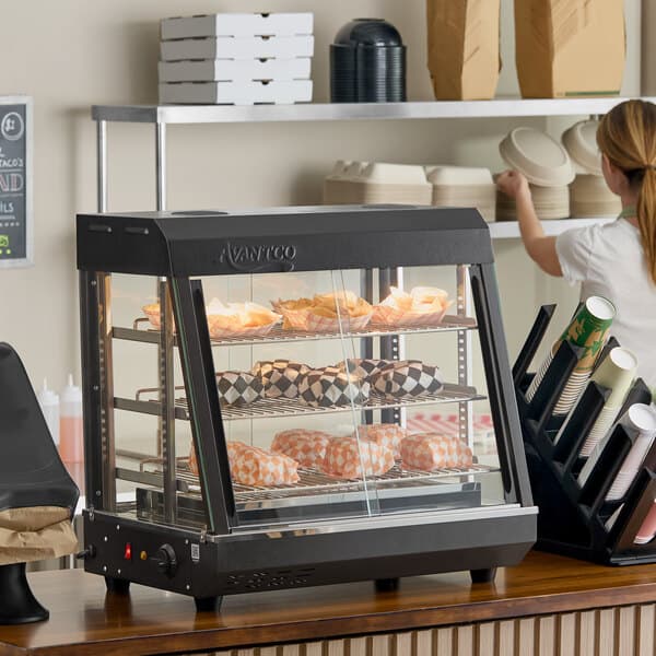 A countertop heated display case with three shelves and sliding doors, used for keeping food warm.