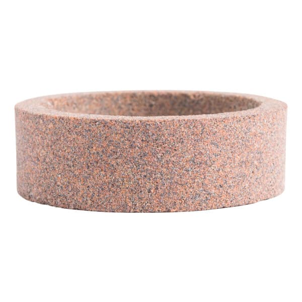 A circular stone sharpening stone with a speckled surface.