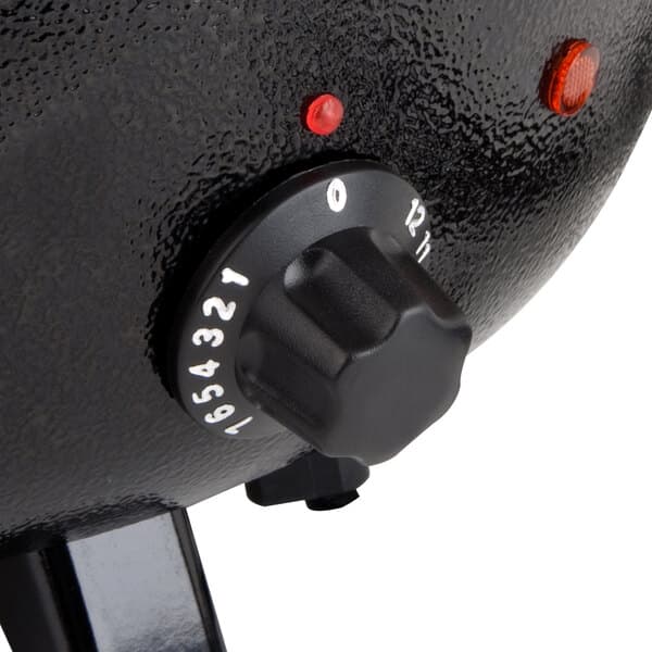 A close-up of a round black dial with white text.