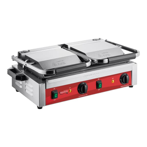An Avantco commercial dual panini grill with red and black plates on a table.