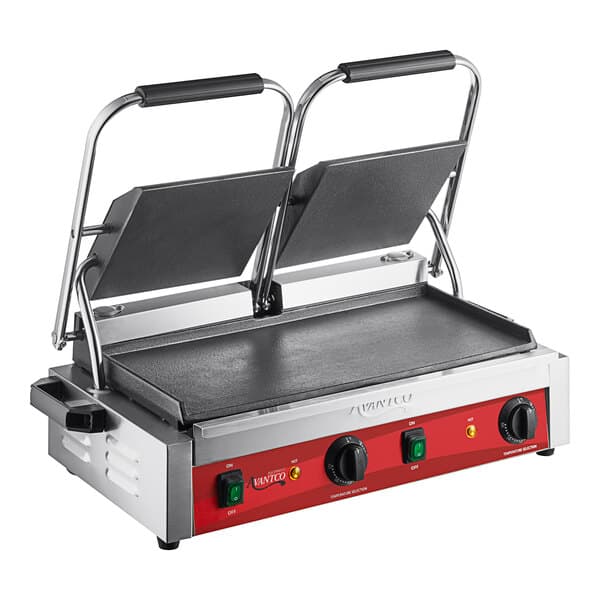 An Avantco commercial dual panini grill with black plates on a table in a professional kitchen.