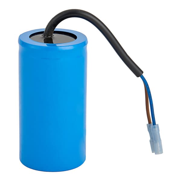 A blue rectangular capacitor with white edges and two black and white wires.