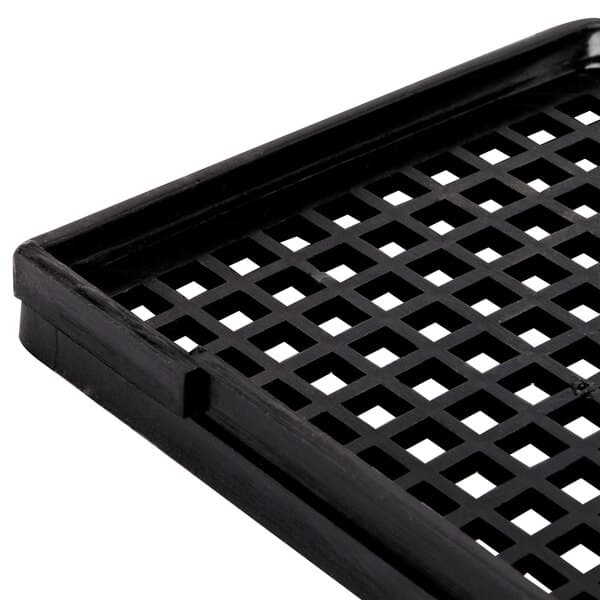A black plastic reservoir screen with a grid pattern of holes.
