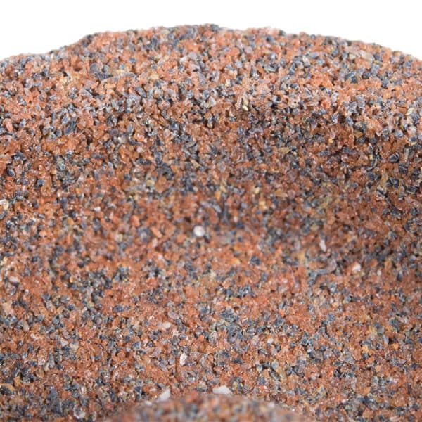 A close up of a sharpening stone with red and gray speckles.