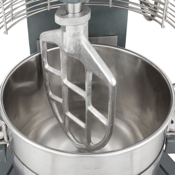 A close-up of an Avantco cast aluminum flat beater in a metal bowl on a mixer.