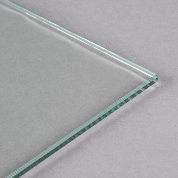 An Avantco glass panel with a green edge on a white surface.