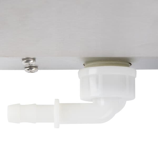 A close-up of a white plastic male fitting on a metal surface.