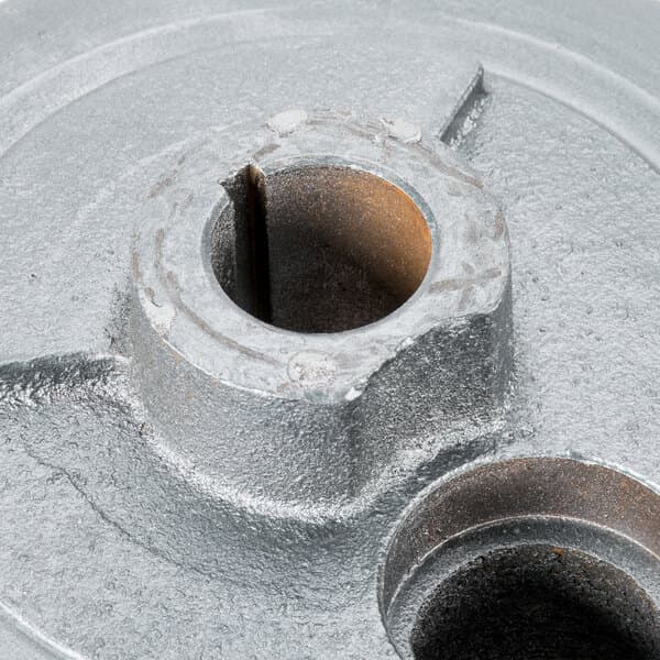 A close-up of a metal turning plate with holes.