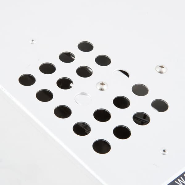 A white metal drawer surface with holes.