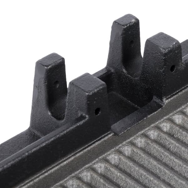 A close-up of the grooved black metal bottom of an Avantco grill plate.