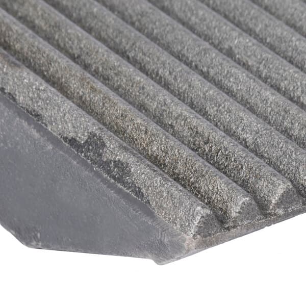 A close-up of a grey metal surface with grooves.