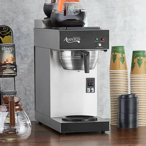 A silver Avantco automatic coffee maker with coffee pots on a table.