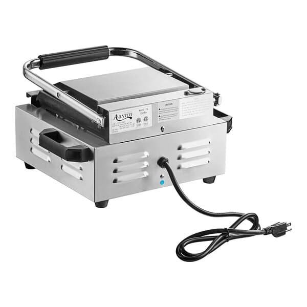 An Avantco commercial panini grill with smooth and grooved plates and a black cord.