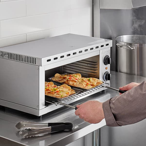 An Avantco electric countertop cheese melter cooking food in an oven.