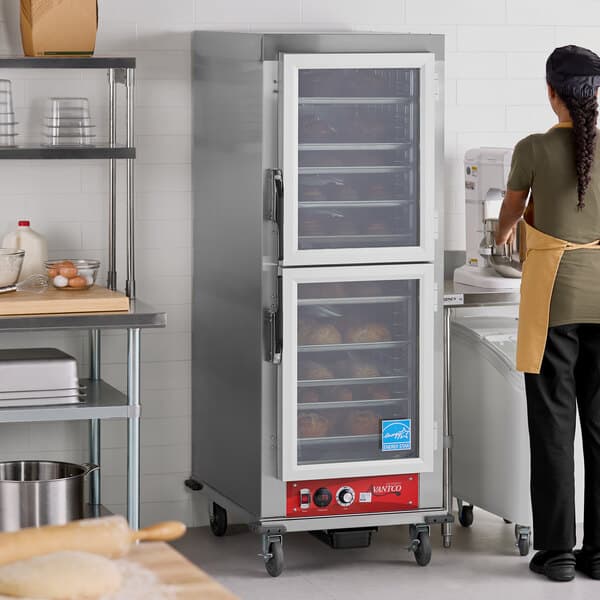 A full size vacuum-insulated heated holding cabinet with clear Dutch doors in a commercial kitchen setting.