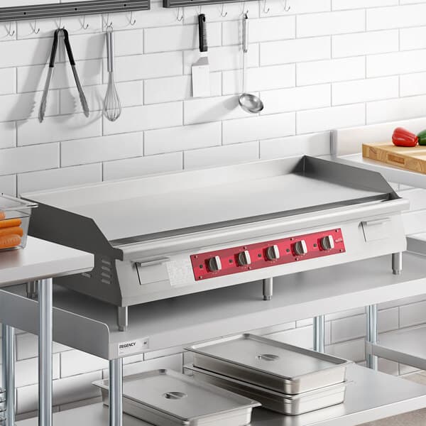 A large stainless steel electric countertop griddle with four control knobs and a red front panel, designed for commercial kitchen use.